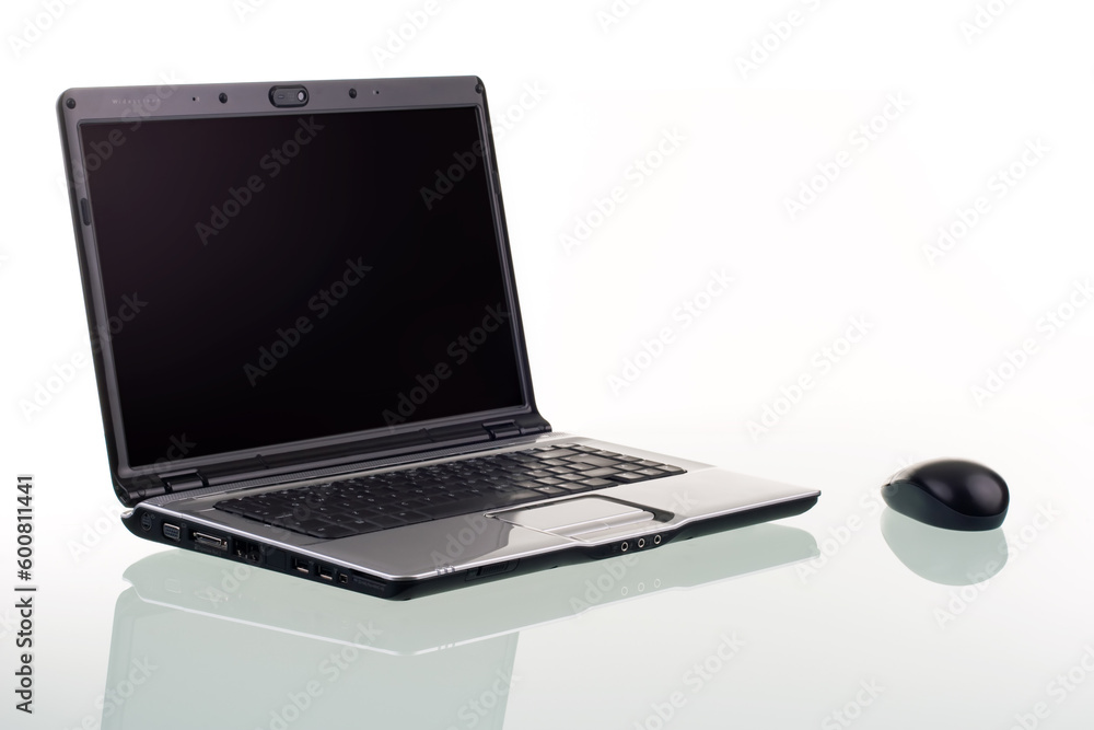 Poster a modern laptop computer and wireless mouse with reflection on a glass surface.