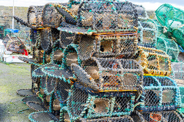 Lobster traps or lobster pots stacked up on the quayside