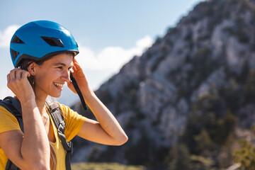 The girl puts on a helmet for mountaineering and climbing. Safety in extreme sports. adventure and active lifestyle.