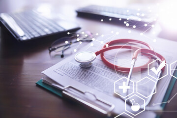 Stethoscope, test tubes, laptop, prescriptions, glasses on the table. Doctor`s desk in the clinic's office.