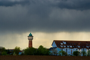 Dark storm clouds over city buildings and water tower