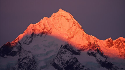 Fototapeta na wymiar Sommet d'une chaine de montagne enneigée à la lueur rouge du soir ou du matin