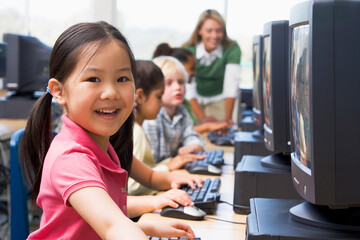 Kindergarten children learning how to use computers. - obrazy, fototapety, plakaty