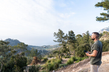 Naklejka premium Man operating the drone by remote control and having fun