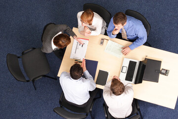 five business people meeting - Businesspeople gathered around a table for a meeting, brainstorming....
