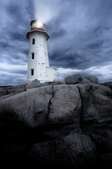 The lighthouse at Peggy's Cove in Nova Scotia Canada at dusk as a storm grows.
