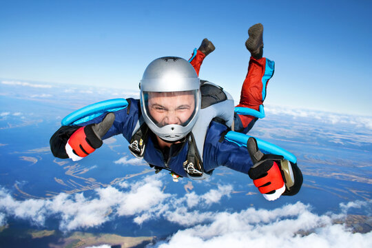 Skydiver falls through the air. All right! Thumbs up! Parachuting is fun!