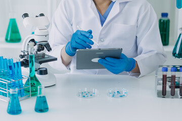 Medical Development Laboratory: Caucasian Female Scientist Looking Under Microscope, Analyzes Petri Dish Sample. Specialists Working on Medicine, Biotechnology Research in Advanced Pharma Lab
