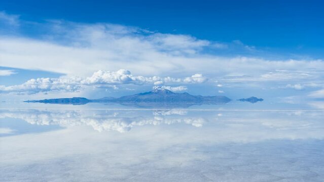 Uyuni Salt Flats. Altiplano, Bolivia. Rainy Season. Tunupa Volcano. Clouds Reflection on Water in Lake Surface. Time Lapse