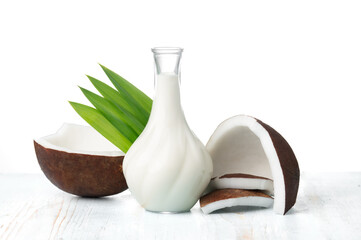 Coconut and coconut milk in glass jug on wooden table - 600826824