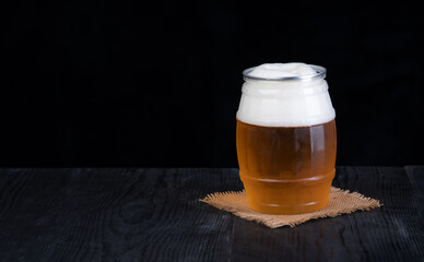 Glass of beer on wood table isolated on black background