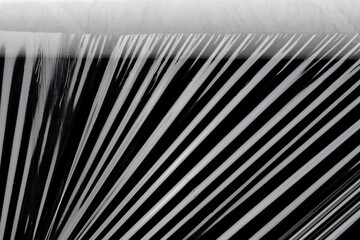 Transparent plastic wrap texture on the black background. Plastic bag texture. Reusable trash and waste.