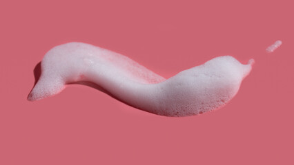 White soap foam, suds of detergent, cleaning gel or shampoo on pink backdrop