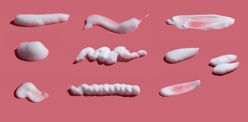 White soap foam, suds of detergent, cleaning gel or shampoo on pink backdrop