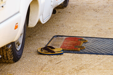 Flip flops on wiper in front of camper car