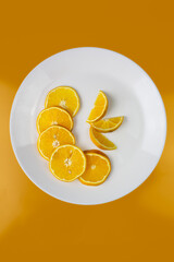 naranja rebanada servida en un plato blanco y un mantel de color amarillo