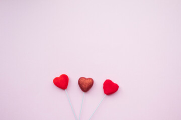 Heart sticks on pink background.