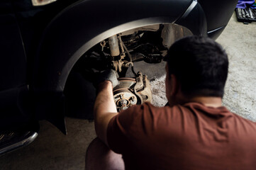 Car disc brake for repair, in the process of replacing a new tire. Repair of car brakes in the...