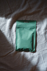 Kraft green paper packaging in female hands. Packaging for coffee, cosmetics. Packing close-up....