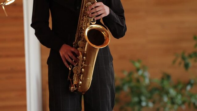 saxophonist in black suit playing the saxophone