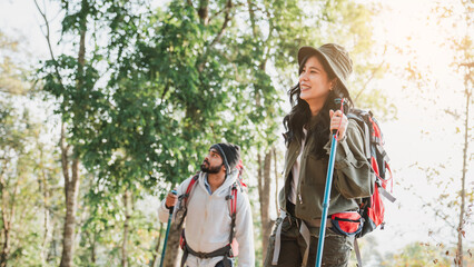 Travelers hiking with backpack traveling in forest wild and look around and explore while walking in nature wood. happy holiday vacation trip.