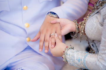 close up hand woman bridge waering wedding ring to left finger of man groom with copy space.concept for wedding card background,poster, invitation card 