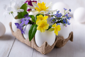 Easter eggs with spring flowers inside on tray.Happy easter background. Easter centerpiece.
