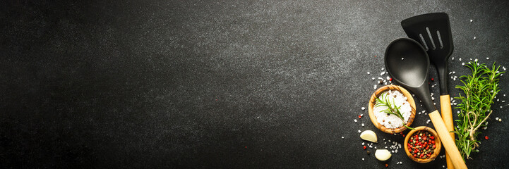 Kitchen utensils with food ingredients on black. Food background. Long banner format.