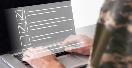 cropped view of soldier gesturing near laptop with blank screen and virtual document