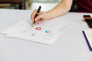 Woman hand with pen and business report. Businesswoman planning strategy with documents at desk. Woman hand working on graph chart analyzing business progress.