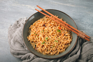 Instant noodles, in a bowl, on a gray table, top view, no people,