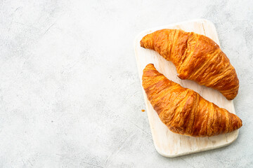 Fresh Croissants on white table. French bakery. Top view with space for text.