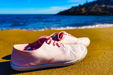 Naklejka premium Female sneakers on sand beach