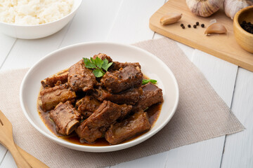 Braised pork spare ribs with soy sauce in white plate