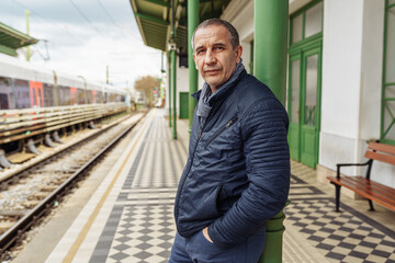 Lonely handsome middle-aged man on blurred background of city street