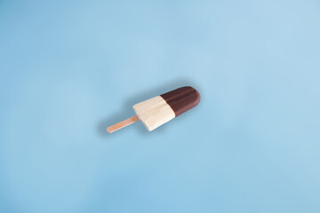 Ice cream made with chocolate and milk. Black and white ice cream on blue pastel background. Minimal summer food concept.