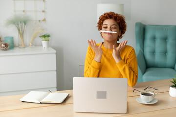 Funny mustache pen joke. Playful young african business woman holding pen like mustache. Girl...