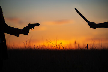 Katana versus revolver fight in the field. Military conflict in Asia. Battle of the big countries....
