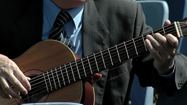 Guitar Player Playing Classical Guitar in a Stadium Seating Tribune in Buenos Aires, Argentina. Close Up.