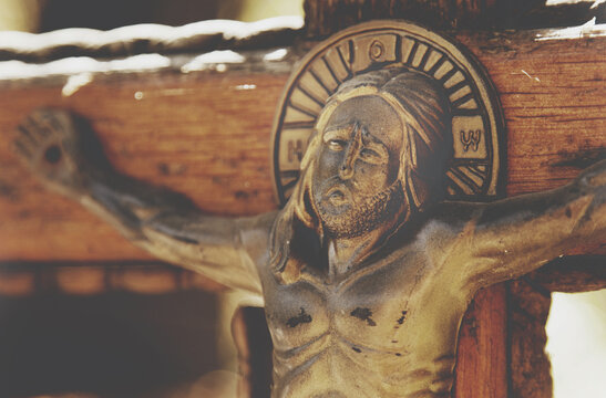 Holy cross with crucified Jesus Christ as a symbol of God's love for people. (Close up an ancient wooden statue)