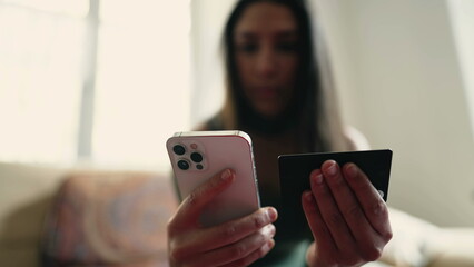 One Arab adult girl in 20s making an online purchase with credit card and phone