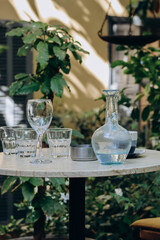 Carafe with water and glasses on a table in the garden