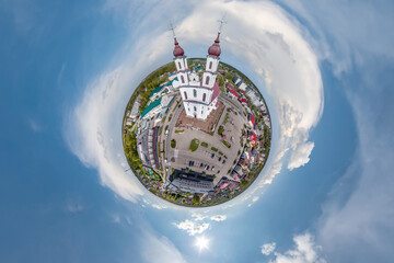 little planet transformation of spherical panorama 360 degrees overlooking church in center of globe in blue sky. Spherical abstract aerial view with curvature of space.