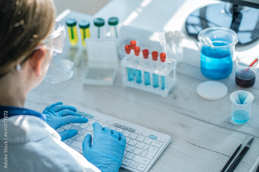 Poster A neurologist analyzes data on patients with neurodegenerative diseases and examines their situation on a computer in a medical laboratory. Scientist typing on keyboard, camera behind