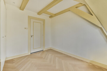 an empty room with white walls and wood flooring on the bottom, there is a door in the corner