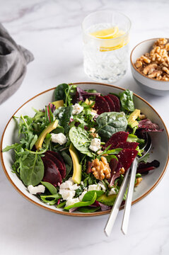 Healthy Salad made from Green Salad Leaves, Rocket Salad, Slices of Beetroot, Avocado, pieces of Feta Cheese, Walnuts and Sesame Seeds.