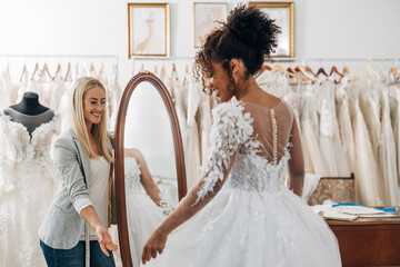 Tailor helps the bride choose the wedding dress of her dreams.