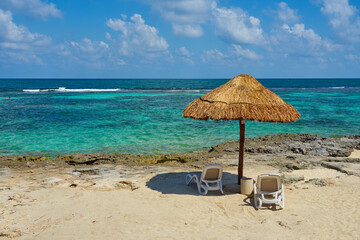 Beach umbrella made of straw on the shores of the Caribbean Sea in Mexico.