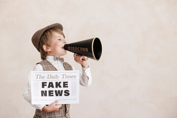 Newsboy shouting against grunge wall background. Boy selling fake news