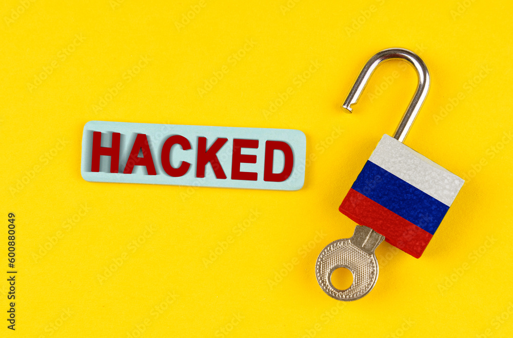 Poster on the yellow surface is an open lock with a key and a sticker with the inscription - hacked
